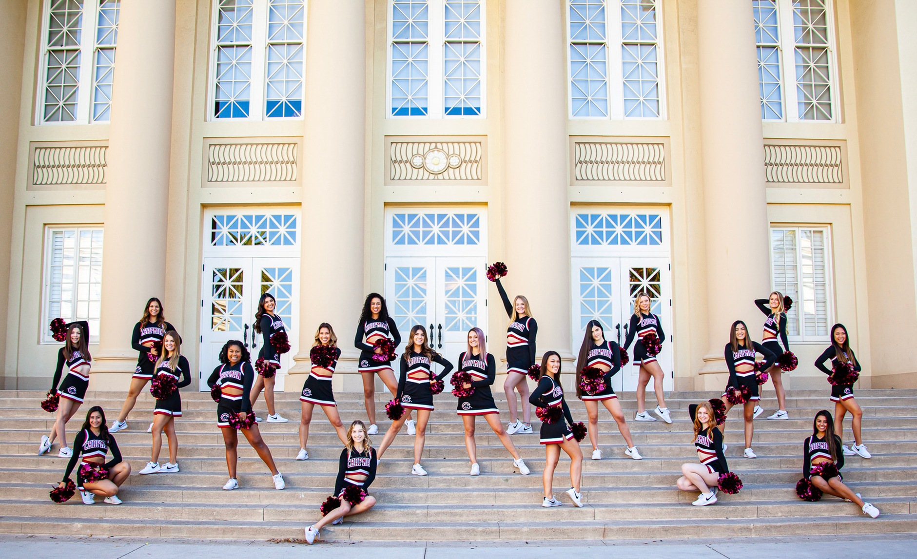 Cheerleaders on steps leading to building.