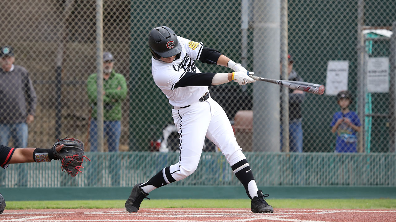 Brad Shimabuku swings and hits a baseball. 