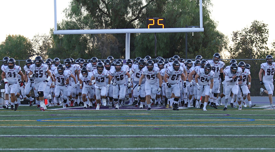 The football team runs out from the end zone.