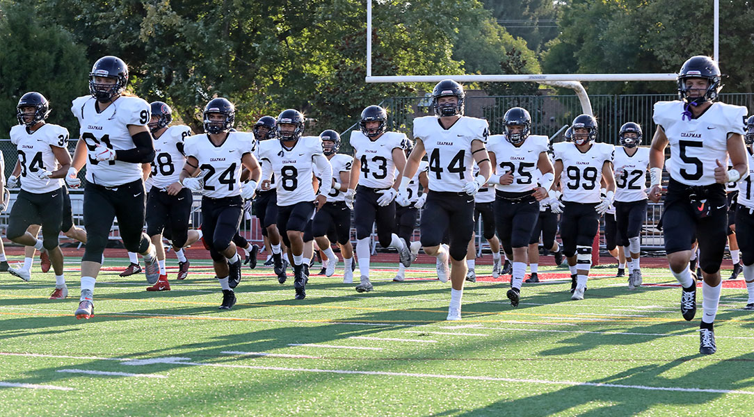 The football team runs on to the field.