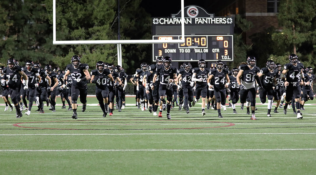 The football team runs onto the field.