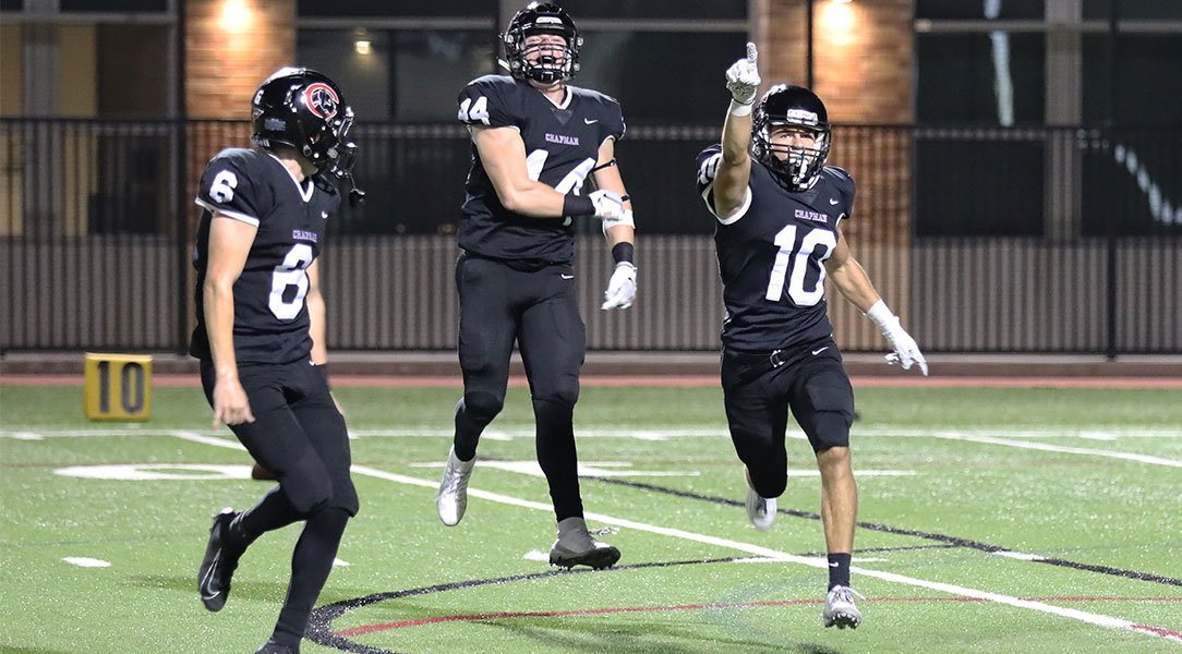 Three defensive players celebrate an interception.