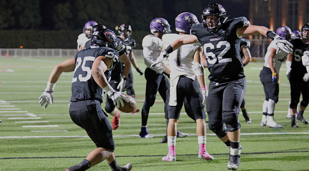 Jacob Wilbanks and Marcos Reyes leap to celebrate a touchdown.