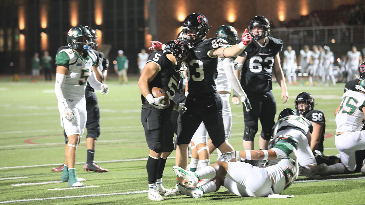 Two Chapman football players celebrate a touchdown.