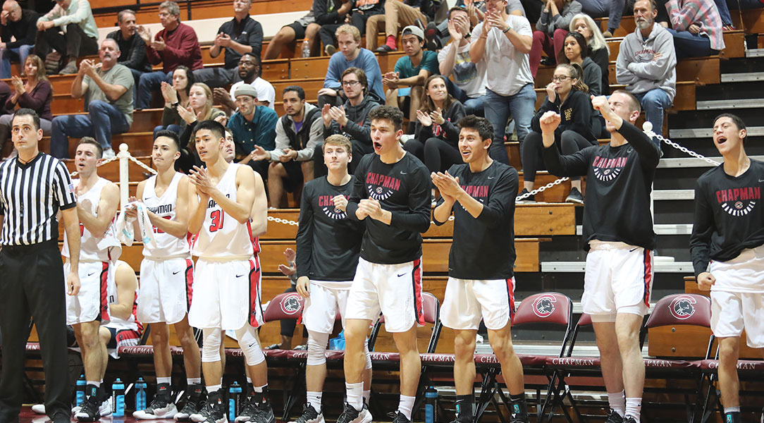 The men's basketball bench cheers.