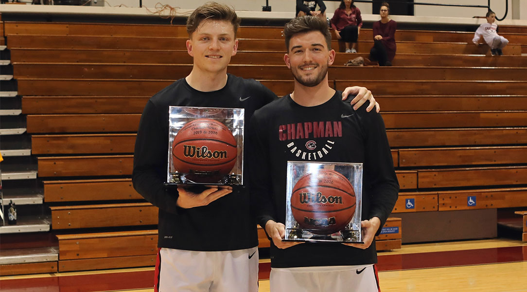 Chandler White and Colin Ferrier holding basketballs in cases.