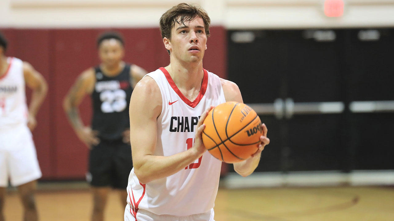 Jake Heberle holding a basketball and shooting a free throw.