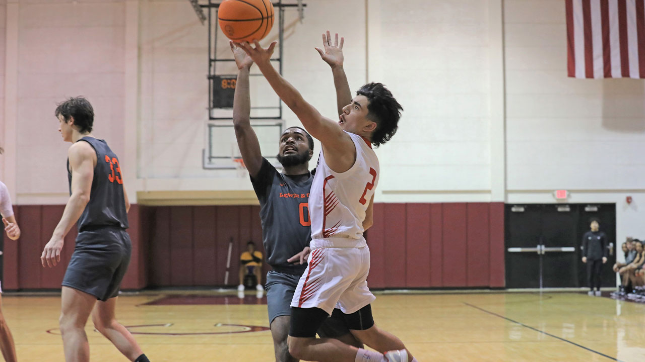 Cruz Billings jumps up and shoots a layup in front of a defender.