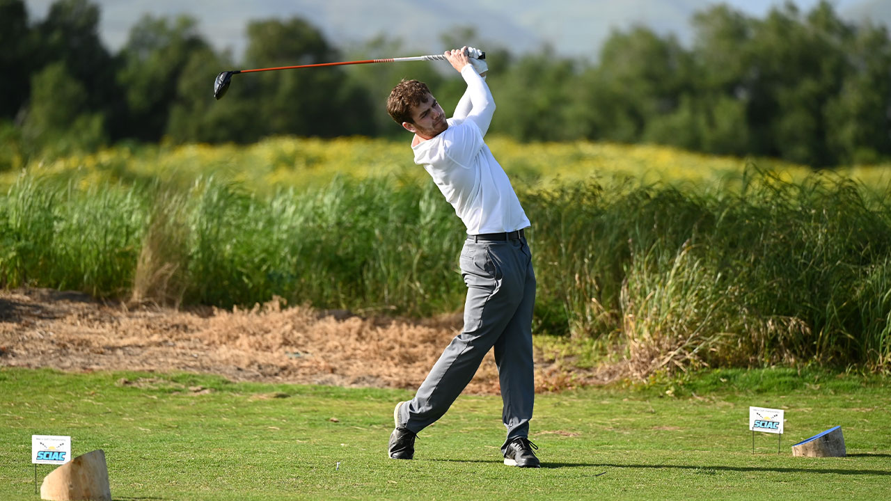 Charlie Shumway hits a golf ball from the tee box.