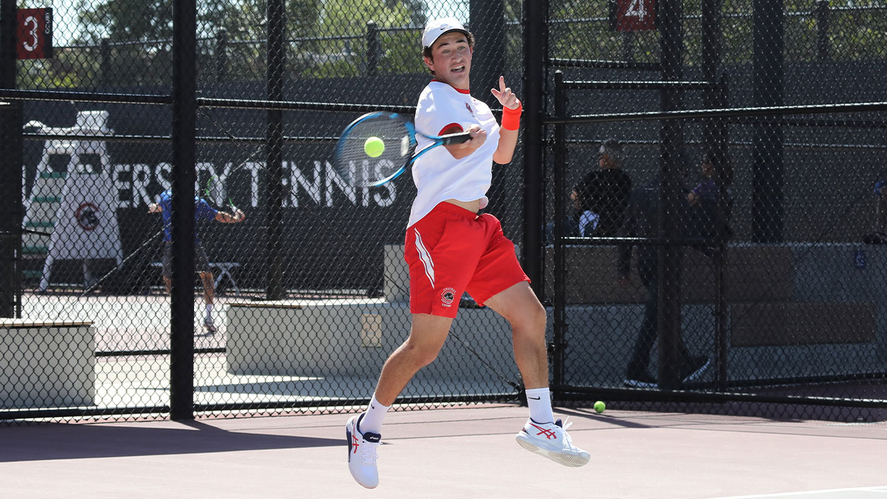 Danny Marsh swings his racket to hit an tennis ball. 