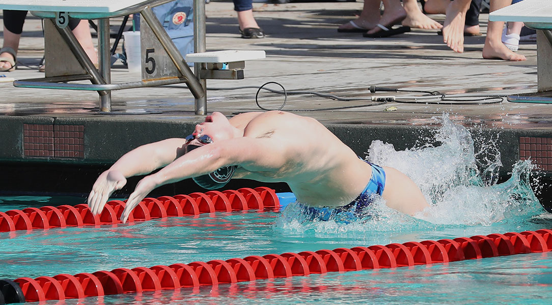 Will Crewe pushes backward off the wall into the pool.