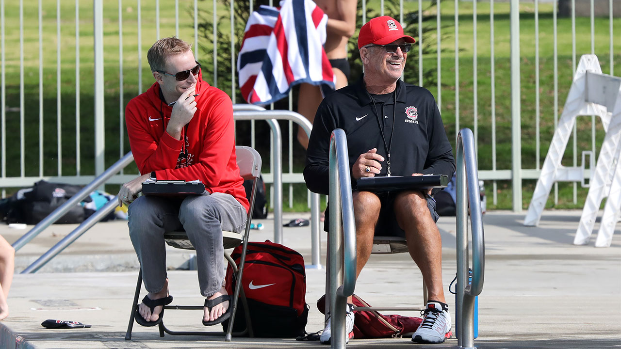 Coaches Erik Sandvig and Dennis Ploessel laughing.