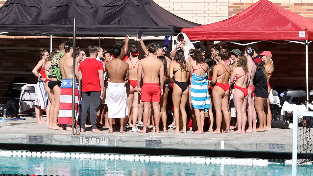The swim teams huddle together.