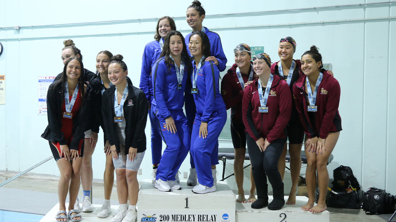 Top-three relays teams of four swimmers standing on the podium.