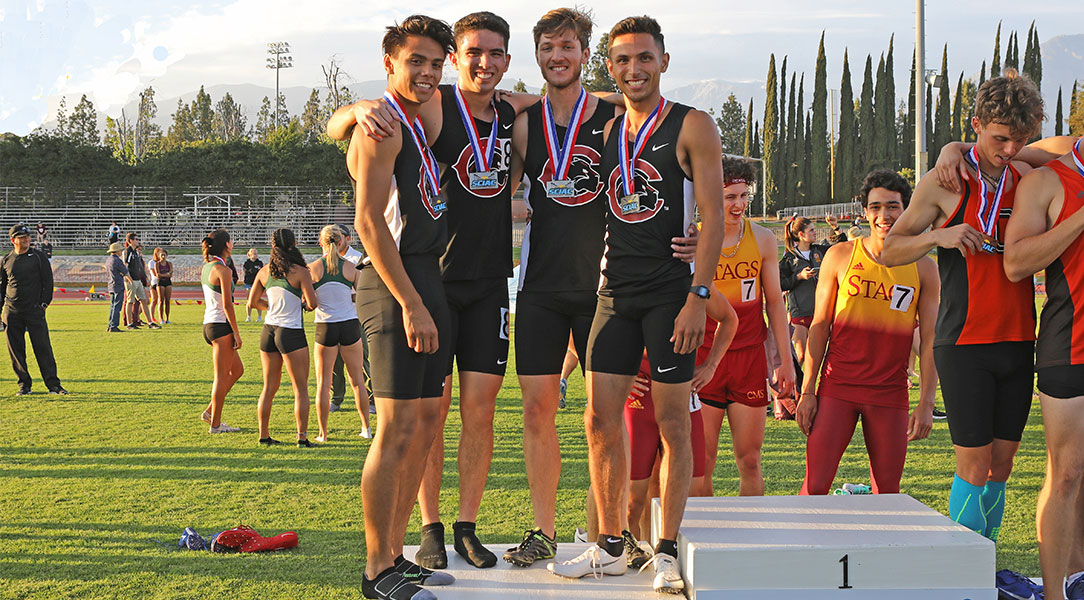 The men's relay team stands on the podium.