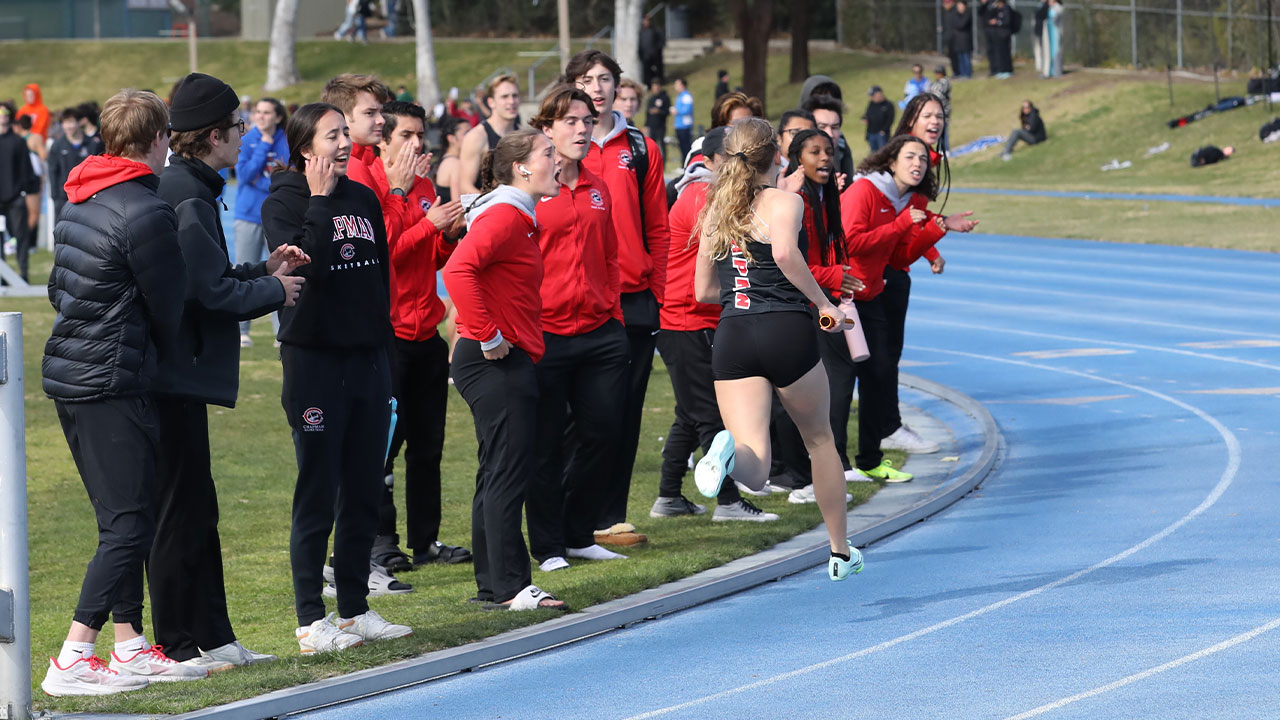 Chapman teammates cheer as a member of their relay runs past them.