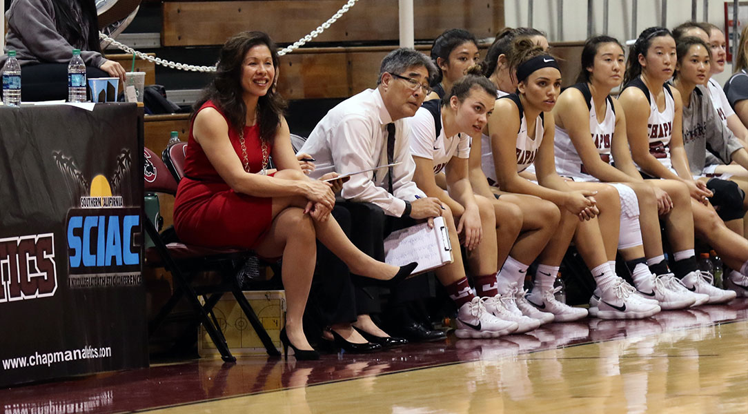 Carol Jue smiles as she looks on from the bench.