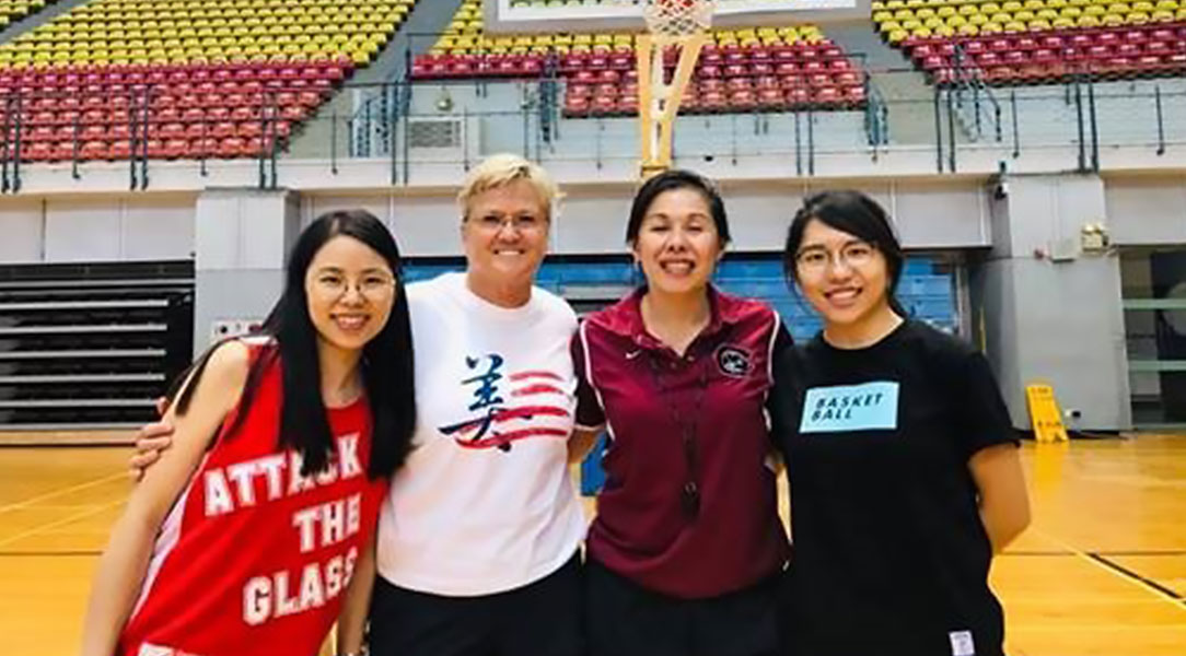 Coach Carol Jue (center right) and Holly Warlick pose with two basketball players during their visit to Taiwan as sports envoys.
