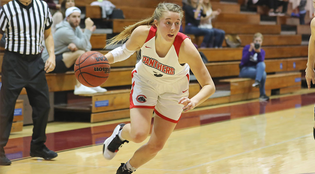 Lucy Criswell dribbles a basketball.