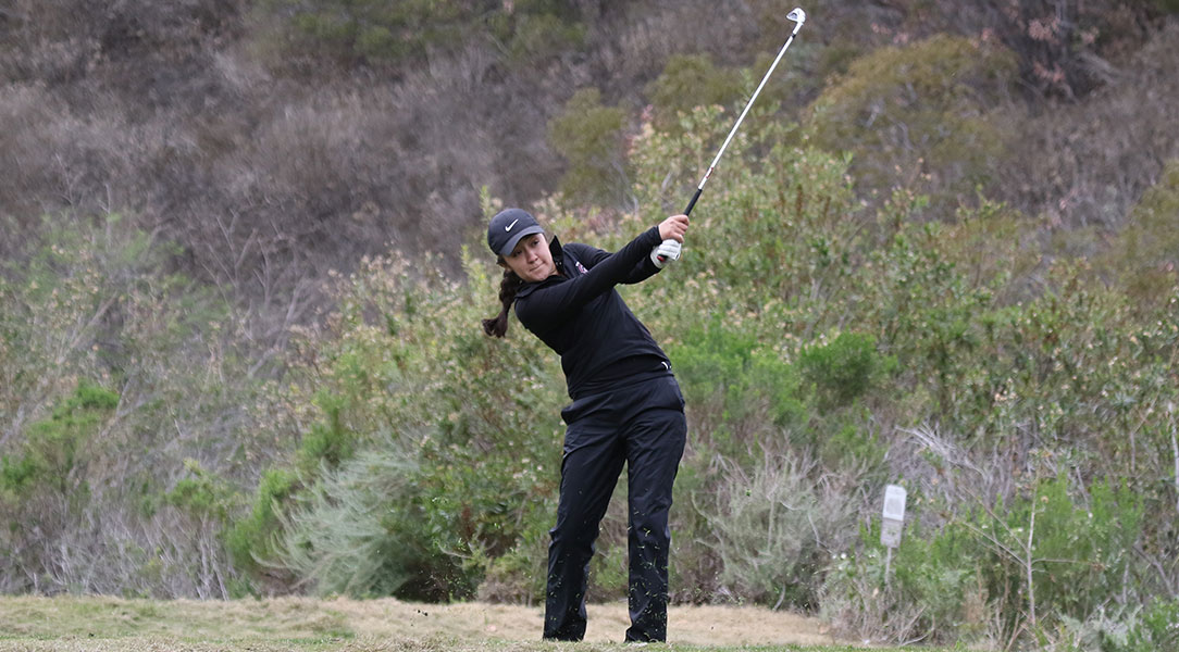 Emily Lewis swings the golf club.