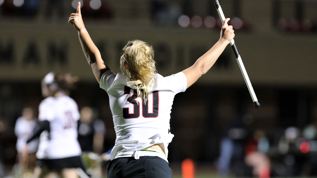 Sophia Bitis raises her hands in celebration of a goal scored.