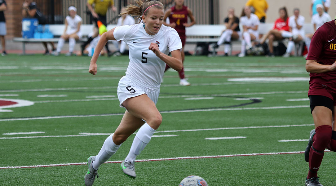 Elly Aronson dribbles the ball.