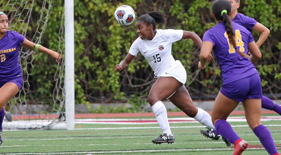Bailee Cochran heads the soccer ball.