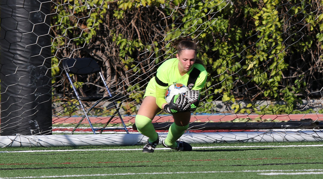 Kelsey Bland scoops up a ball for a save.