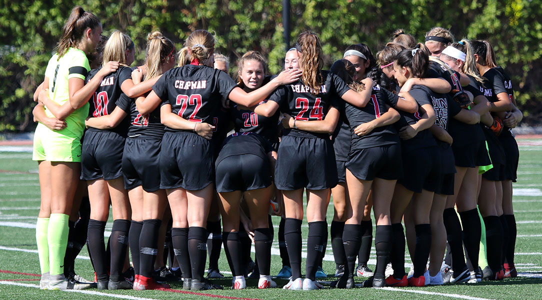 The women's soccer team gathers for a huddle.