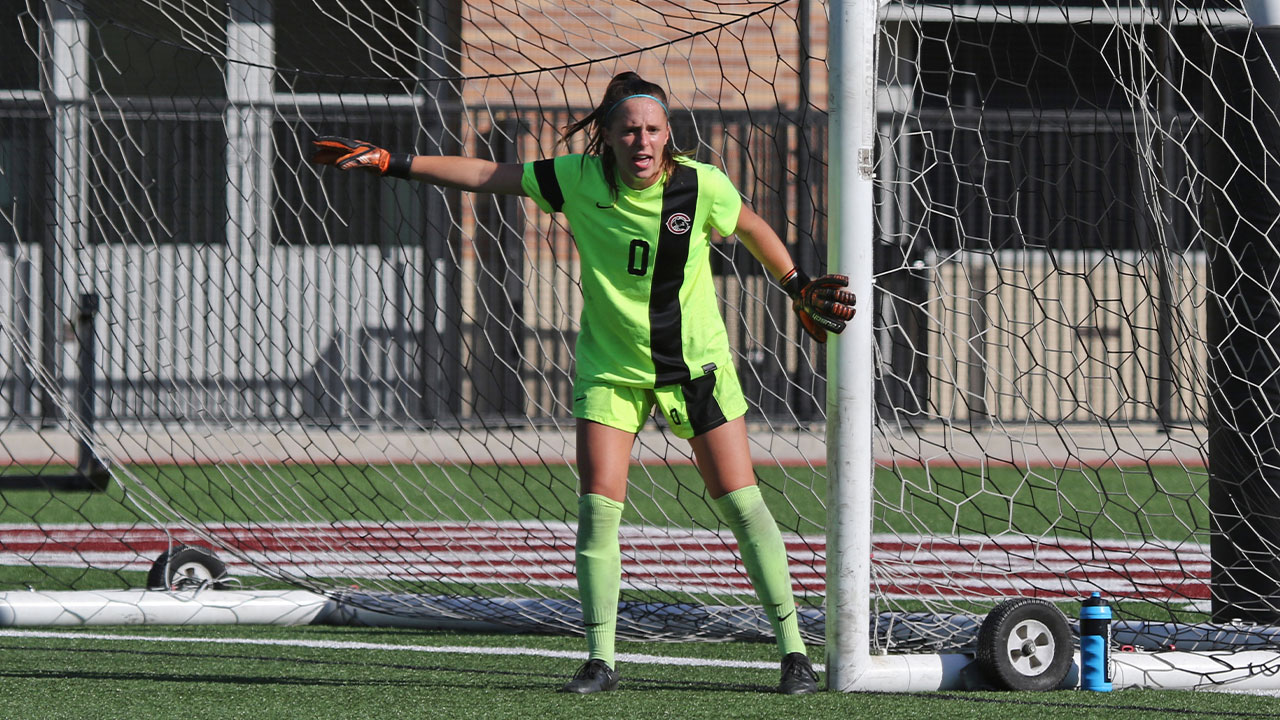 Kelsey Bland stands in the goal.