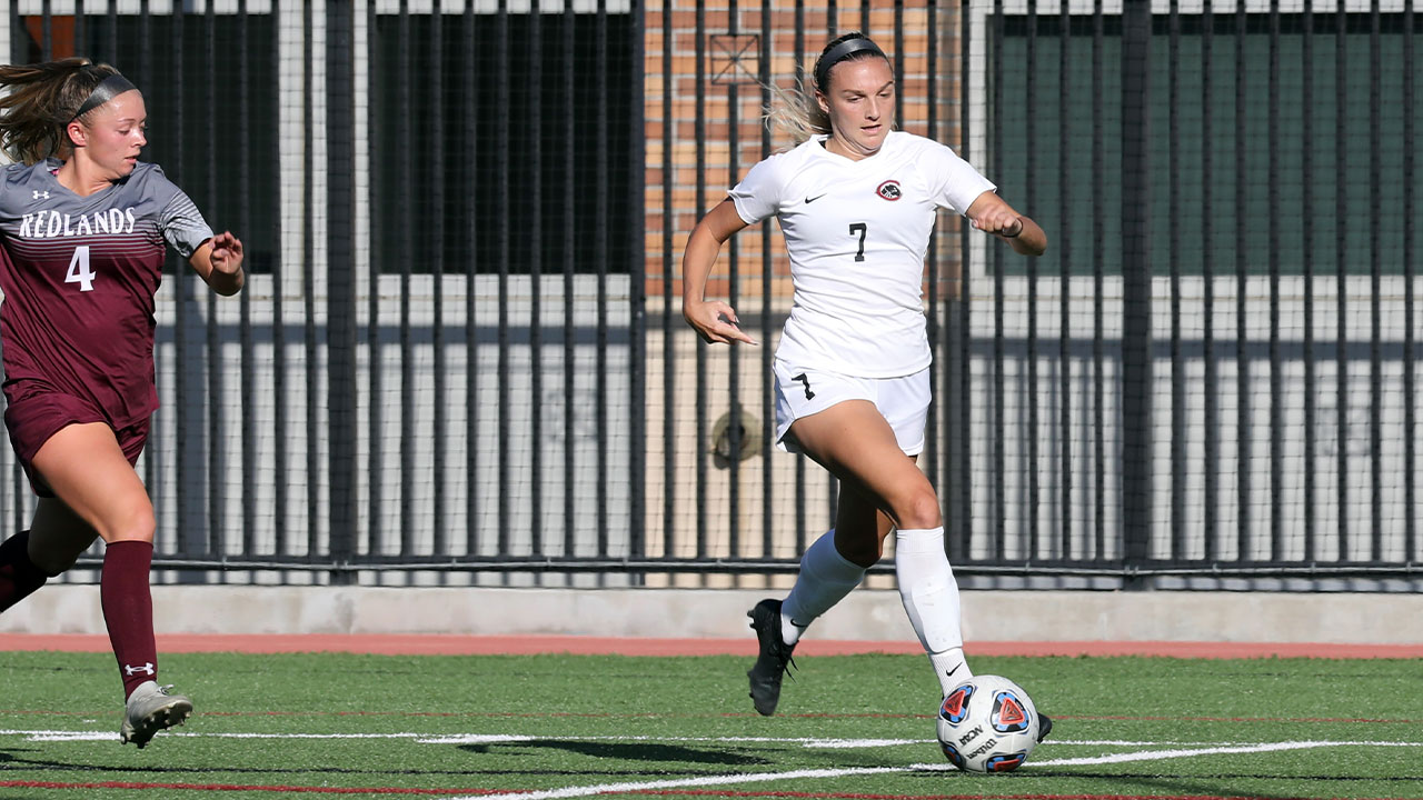 Anna Montemor dribbles a soccer ball by a defender.