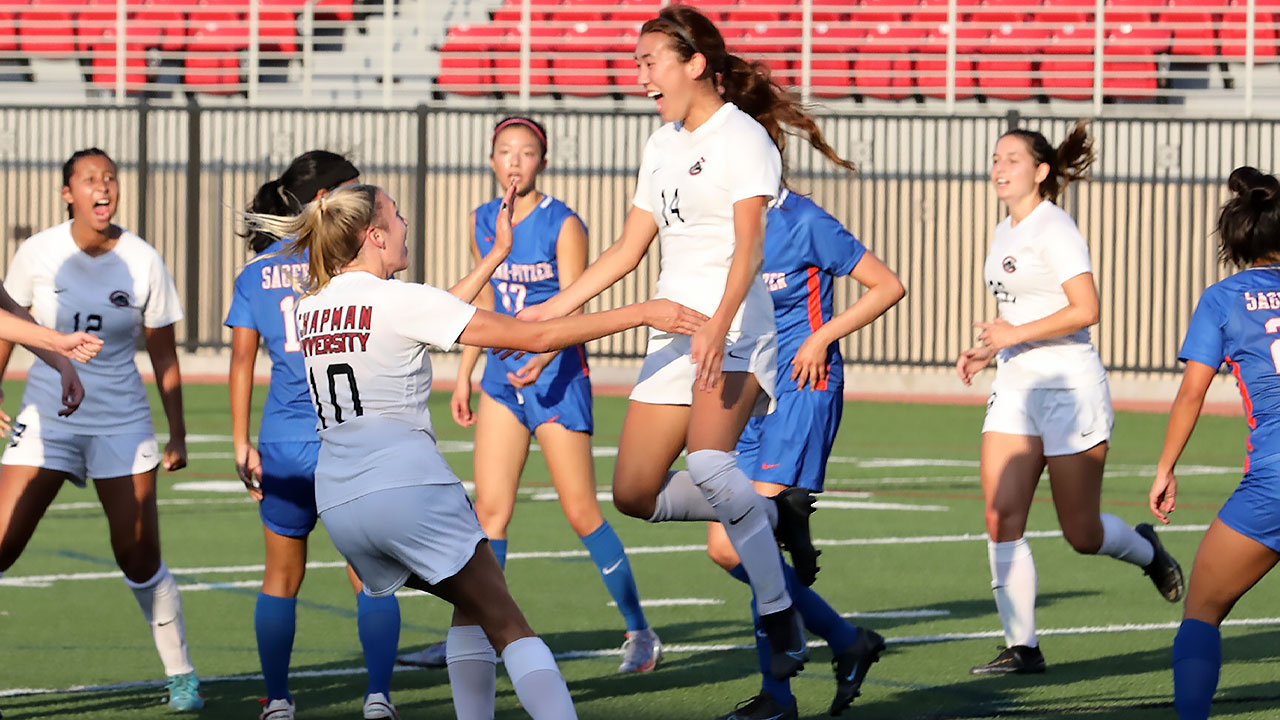 Emma Harper jumps toward her teammate to celebrate a goal.