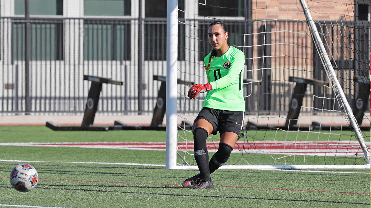 Maia Mills kicks a ball away from the goal.