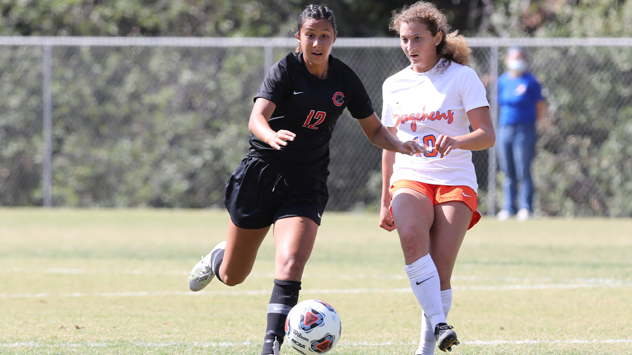 Lily Jose dribbles a soccer ball alongside a defender.