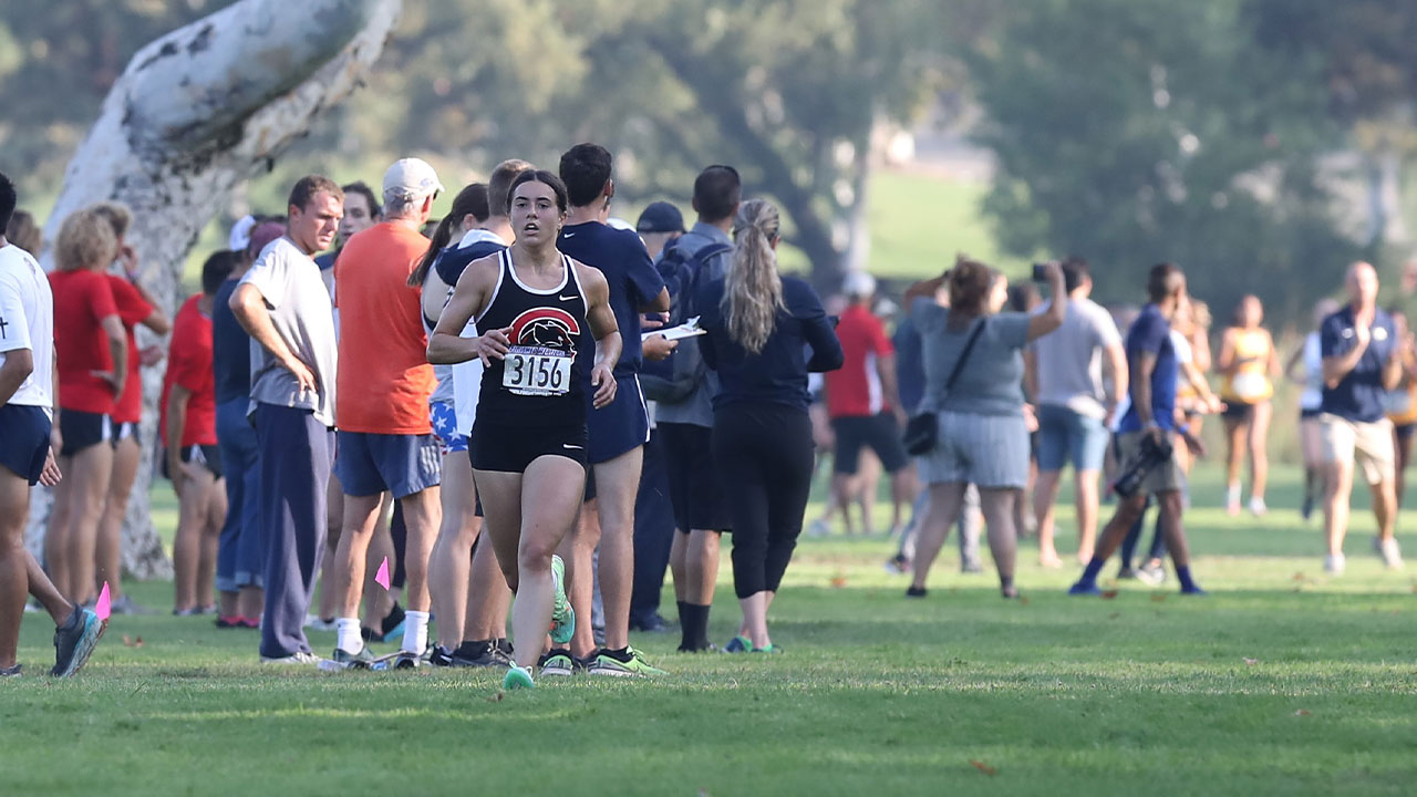 Maddie Mirro running past a crowd.